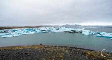 Casal na lagoa glacial de Jokulsarlon, na Islândia
