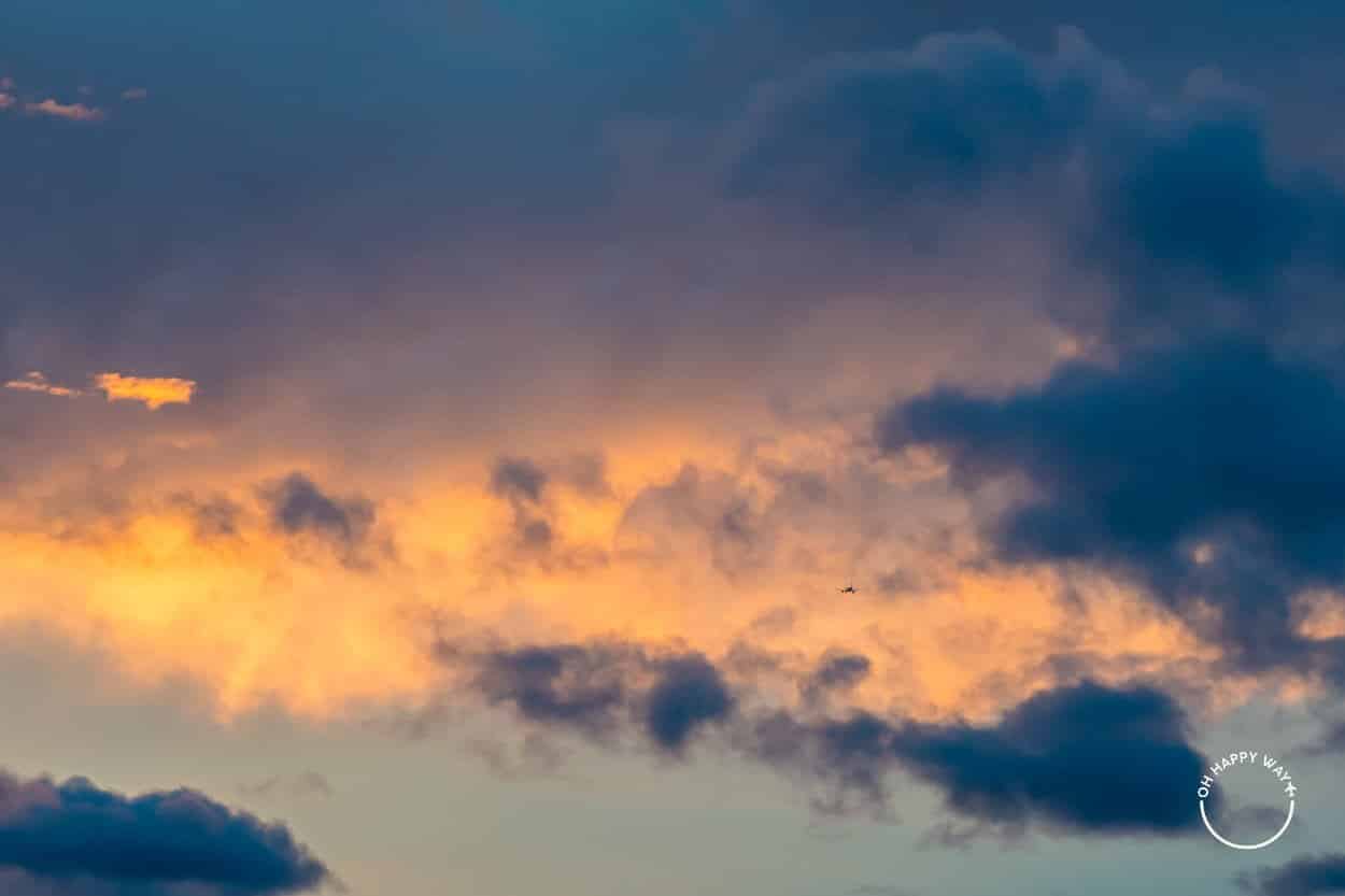 Avião cruzando nuvens coloridas