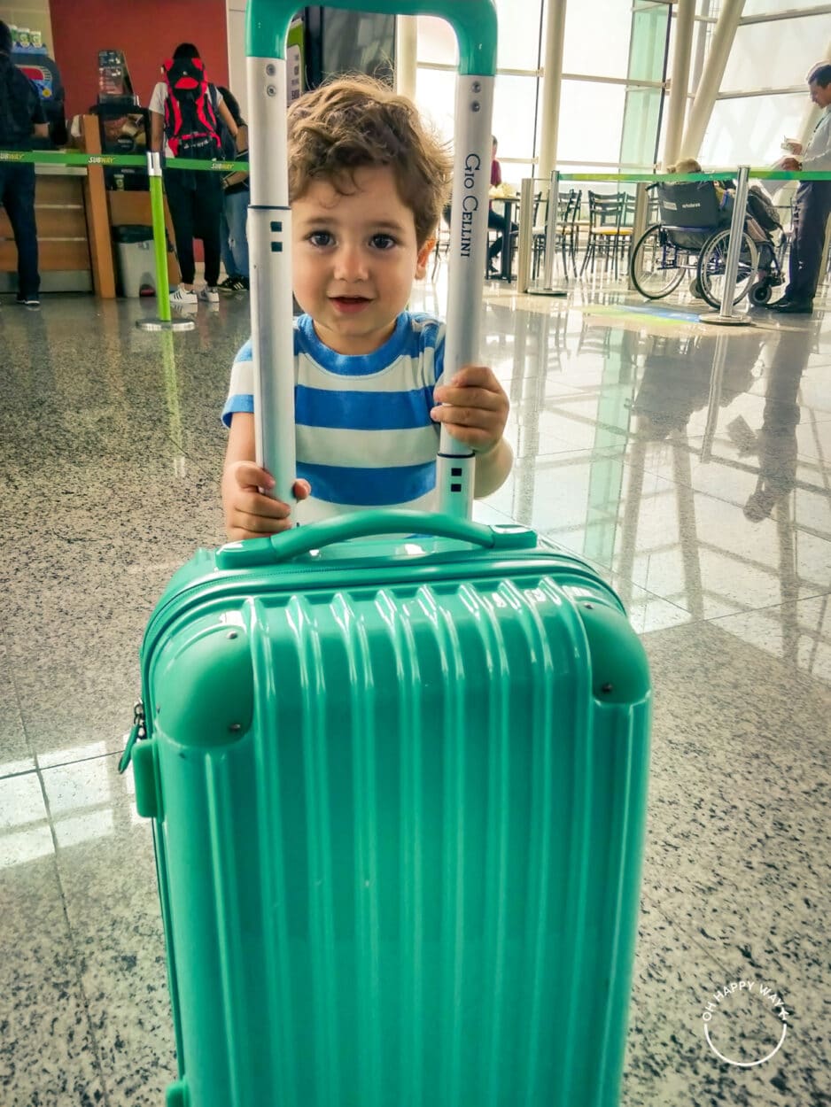 Dicas de viagem com criança: Martin segurando a mala de viagem.