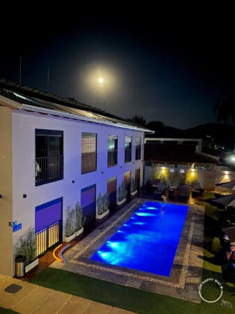 Área dos quartos e piscina iluminada com a lua ao fundo.