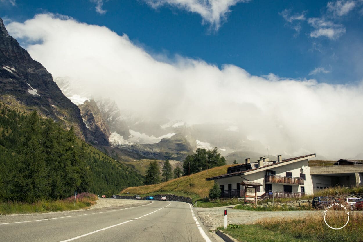 Estrada para a cidade, cercada de montanhas nos Alpes italianos.