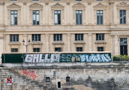 Grafite e prédio à beira do Rio Sena, em Paris.