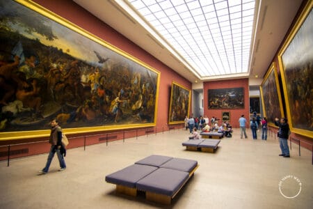 Grandes pinturas em salão no Museu do Louvre