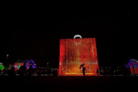 Silhueta em frente a um estrutura imitando uma caixa de presente no Brasília Iluminada.