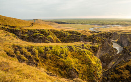 Pessoa observando o cânion Fjaðrárgljúfur, na Islândia.