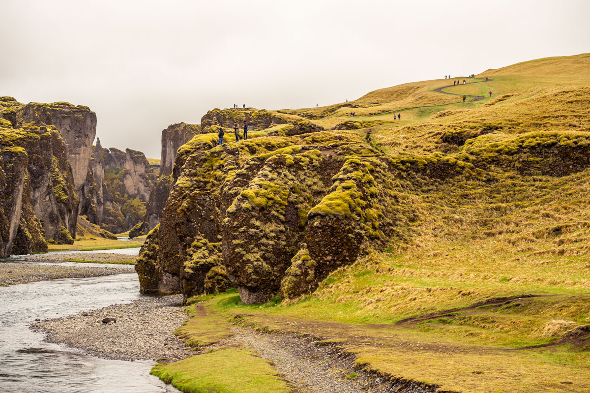 Várias pessoas no cânion Fjaðrárgljúfur, na Islândia.