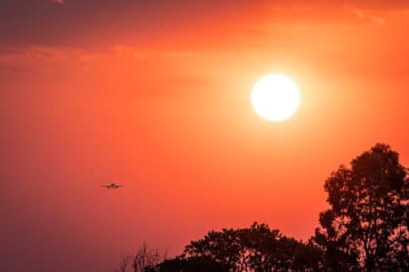 Pôr do sol e avião vistos do aeroporto de Brasília