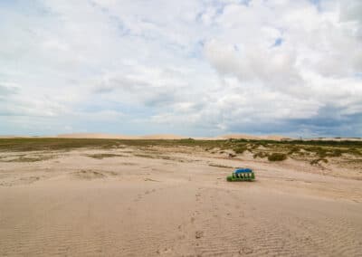 Caminhão jardineira verde em duna em Jericoacoara, no Ceará.