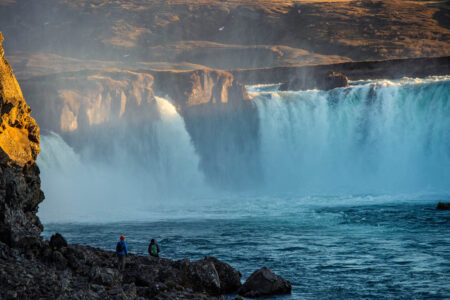 Pessoas em frente às quedas da cachoeira Godafoss, na Islândia