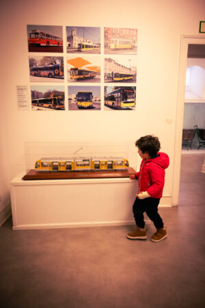 Criança na frente de uma miniatura de trem no museu da Carris