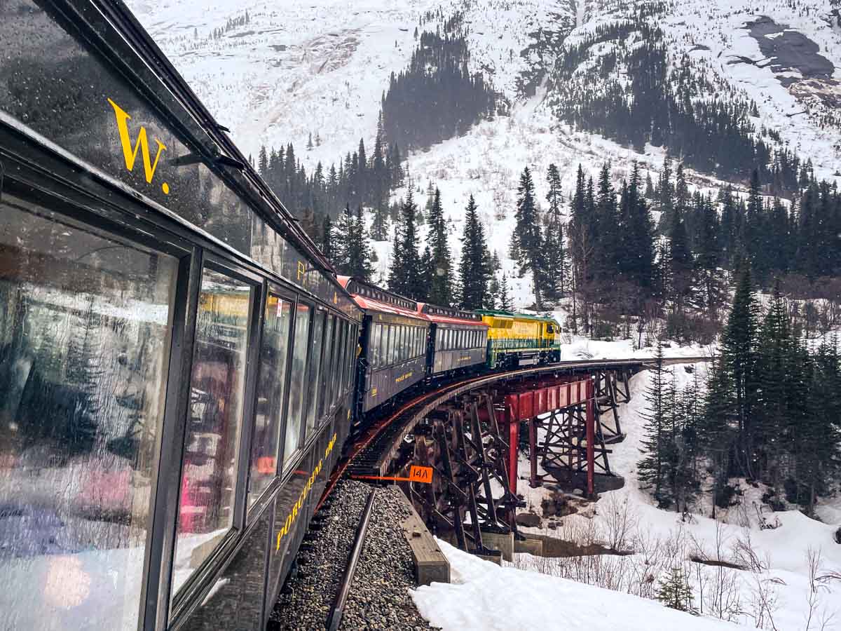 Exemplo de como tirar fotos boas com celular: trem passando em uma montanha nevada.